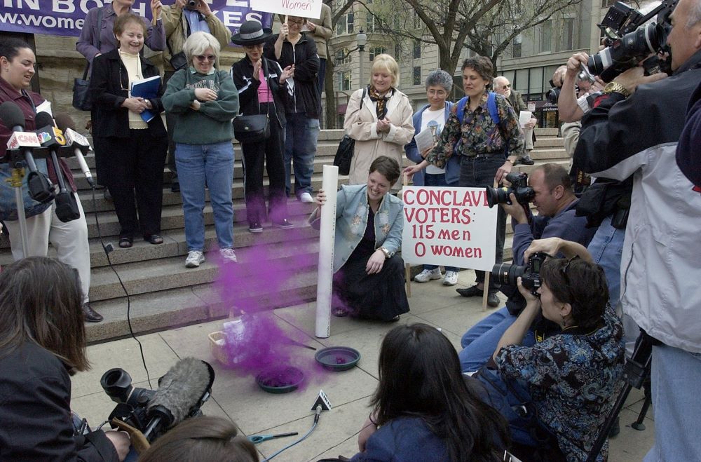 Anne Pezillo of the Women's Ordination Conference sends up "pink smoke" on the steps of Chicago's Holy Name Cathedral April 18, 2005, during a news conference protesting the exclusion of women from the conclave at the Vatican. The next day, cardinal electors chose Cardinal Joseph Ratzinger as pope.