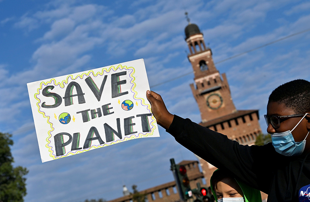 A demonstrator holds up a sign as he attends a Fridays for Future climate strike in Milan Oct. 1, 2021, ahead of the U.N. Climate Change Conference in Glasgow, Scotland. (CNS/Reuters/Flavio Lo Scalzo)
