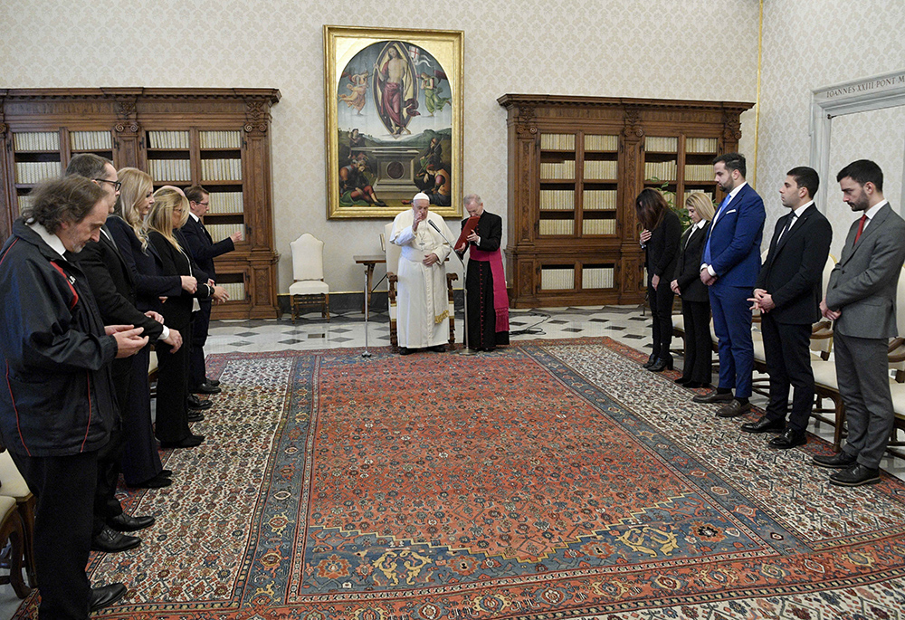 Pope Francis gives his blessing to members of the staff of the Vatican Auditor General's Office at the end of a meeting in the library of the Apostolic Palace Dec. 11, 2023. (CNS/Vatican Media)