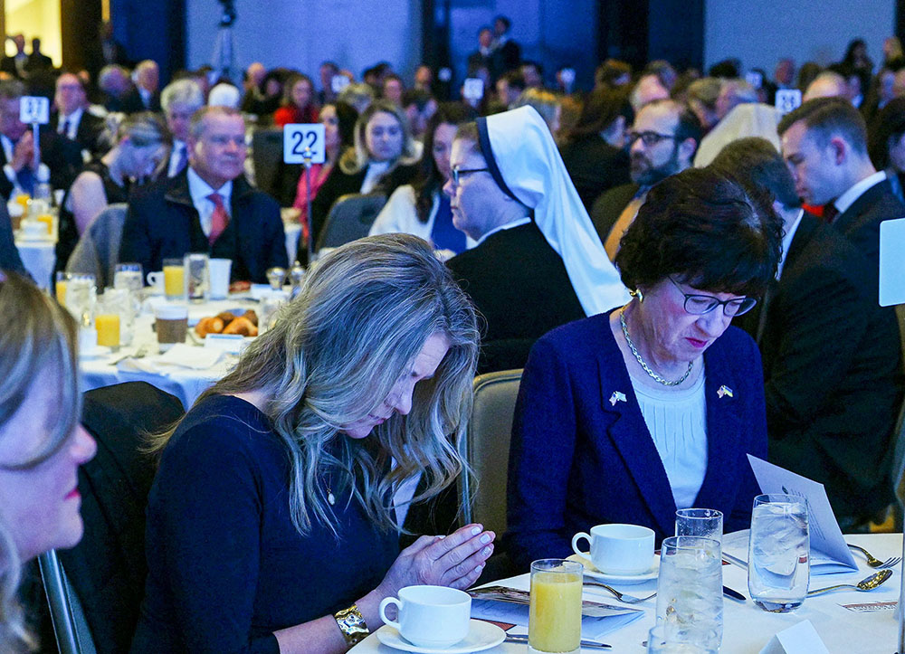 Attendees, including Sen. Susan Collins, R-Maine, right, pray during the National Catholic Prayer Breakfast in Washington Feb. 8. (OSV News/Leslie E. Kossoff)