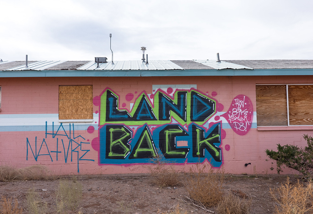 "Land back" wall art is pictured Nov. 23, 2023, near Monument Valley, Arizona. (Flickr/Kevin Dooley, CC BY 2.0)