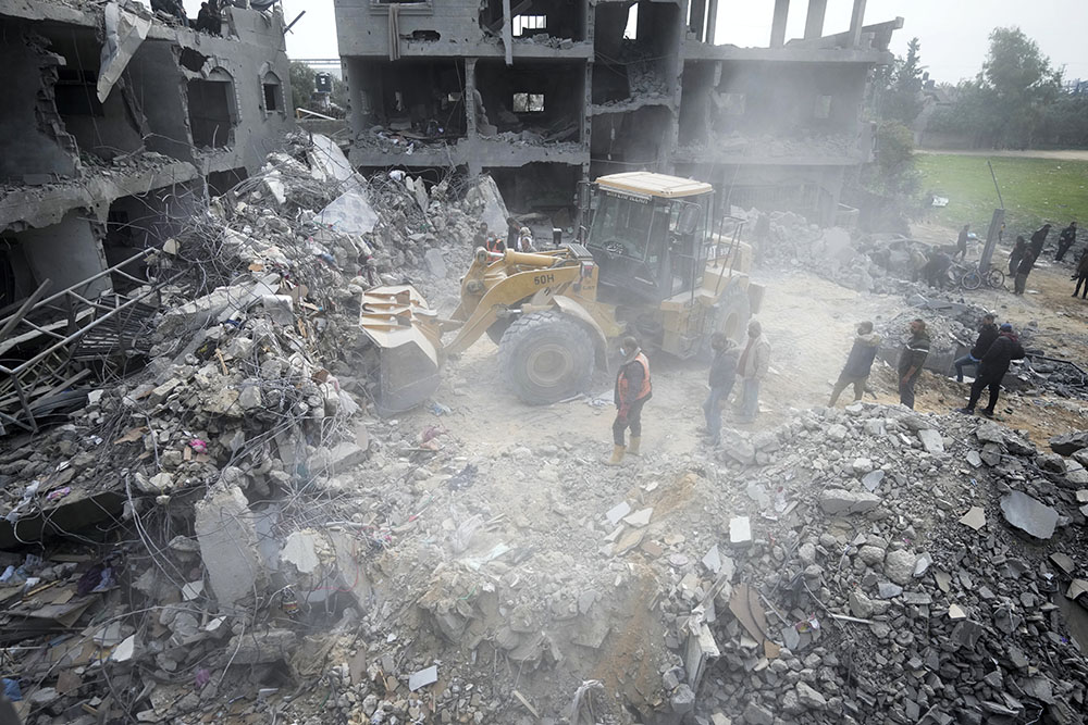 Palestinians search for survivors after an Israeli airstrike on a residential building in Deir al Balah, Gaza Strip, Feb. 23. (AP/Adel Hana)
