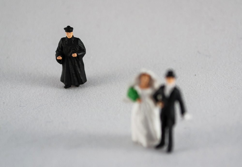 Figurines of a priest and a bride and groom (Dreamstime/3dm1983)