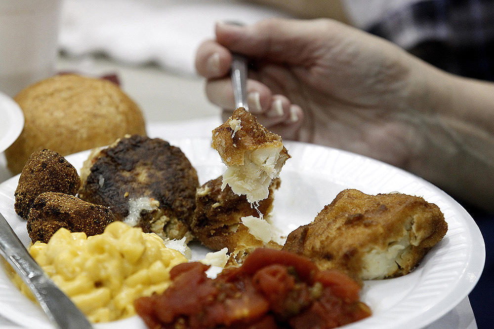 Fried haddock and other items are seen on a guest's plate during a fish fry in the parish hall of St. Mary's Church in Altoona, Pennsylvania. (CNS/Bob Roller)
