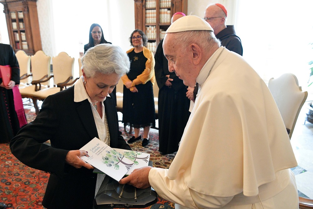 Pope Francis accepts gift from Ilva M. Hoyos Castañeda, a lawyer from Colombia, during a meeting with CEPROME.