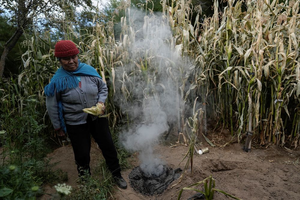 Irene Leonor Flores de Callata, 68, performs a brief ceremony to thank the Earth after inspecting her corn crop at her home in Tusaquillas, Jujuy Province, Argentina, on April 23, 2023. 