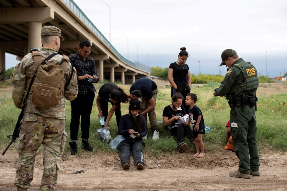 A Customs and Border Protection agent near the southern border town of Eagle Pass, Texas, collects biographical information from a group of Venezuelan migrants April 25, 2022, before taking them into custody. In recent mont