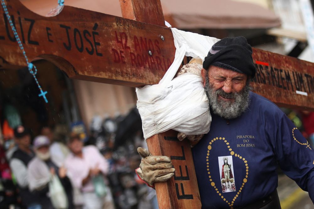 A worshipper carries a cross during the Good Friday procession in Pirapora do Bom Jesus, Brazil, on April 7, 2023. 