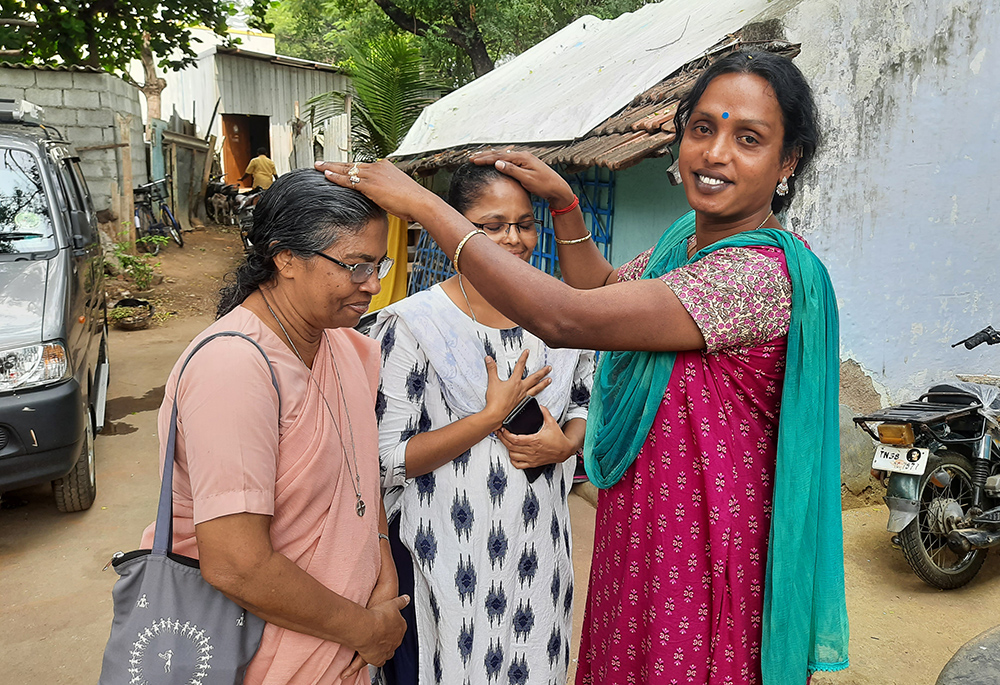 Kovai Meera, a trans woman, blesses Srs. Stella Baltazar and Anita Edwin, members of the Franciscan Missionaries of Mary, at her residence in Coimbatore, a major city in Tamil Nadu state in southern India. (Saji Thomas)