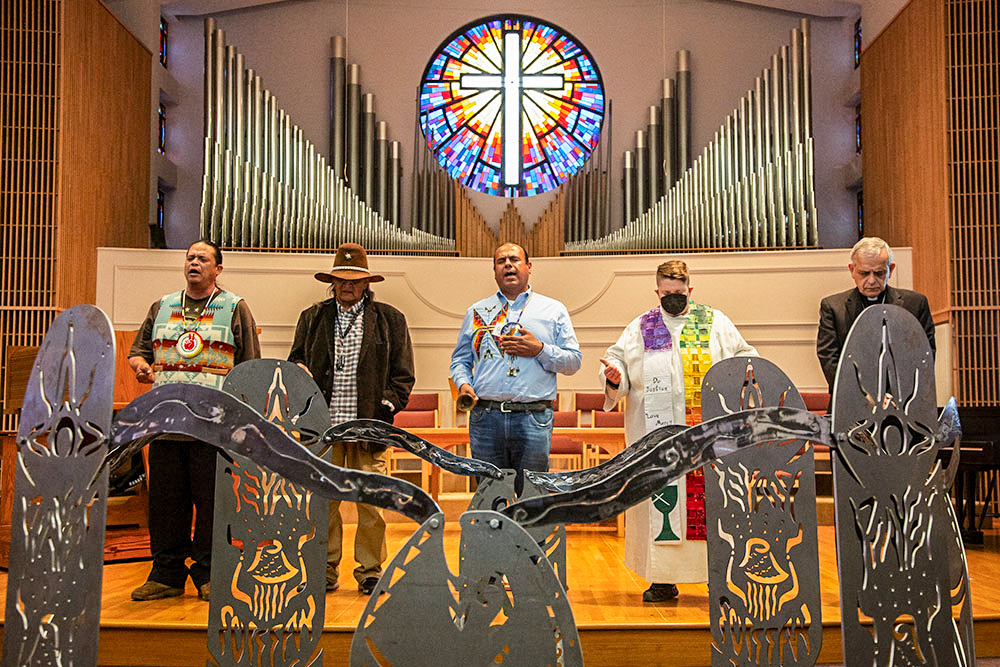 JoDe Goudy (center), vice-president Se’Si’Le’; the Rev. AC Churchill (second from right), executive director Earth Ministries/Washington Interfaith Power and Light; Seattle Auxiliary Bishop Eusebio Elizando (right); and other participants lead the community in prayer on Sept. 23, 2023, at an All Our Relations campaign event organized by Se’Si’Le’ in Olympia, Washington, at United Churches of Olympia. (Courtesy of the Nez Perce Tribe)