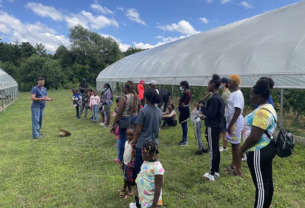 A native plants expert trains a group of Congolese refugees in the All Saints Church environmental task force's garden in Syracuse, New York, in summer 2023. (Courtesy of Michael Songer)