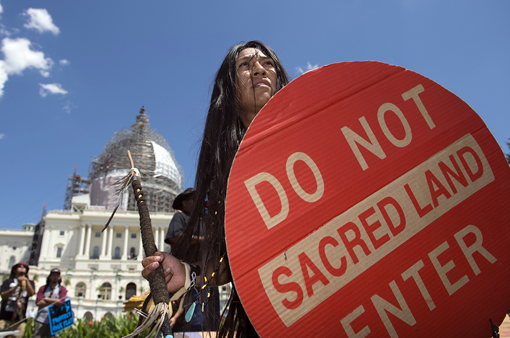 An Apache activist dancer performs in a rally to save Oak Flat, land near Superior, Ariz., sacred to Western Apache tribes, in front of the U.S. Capitol in Washington, July 22, 2015. An Apache group that has fought to protect land it considers sacred from a copper mining project in central Arizona suffered a significant blow March 1, 2024, when a divided federal court panel voted 6-5 to uphold a lower court's denial of a preliminary injunction to halt transfer of land for the project. (AP/Molly Riley, File)