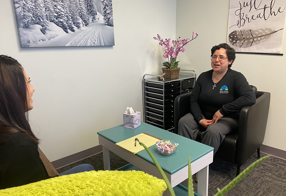  Sr. Veronica Fajardo, who provides counseling services at no cost to clients of Holy Cross Ministries, speaks with a client. (Courtesy of Lauren Fields/Holy Cross Ministries)