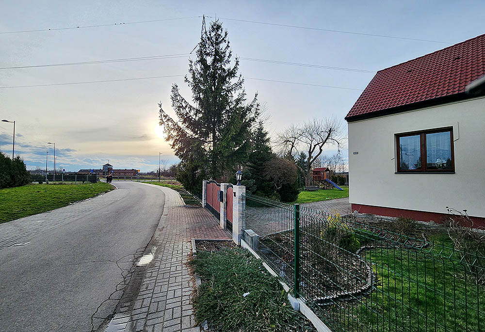 In a recent photo, a residence on the right stands not far from the Auschwitz-Birkeanau memorial site seen at left. (NCR photo/Chris Herlinger)