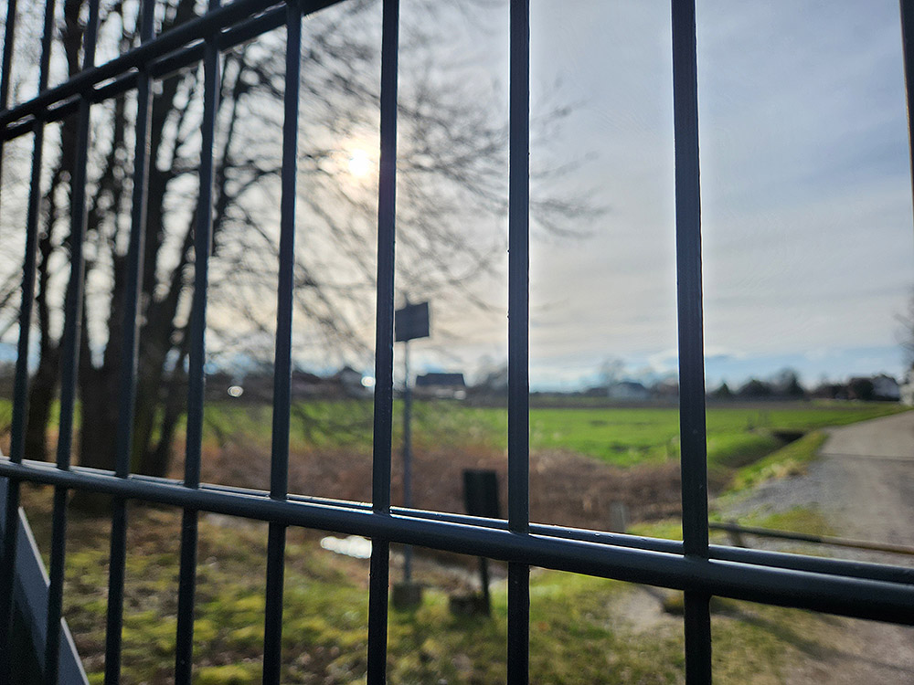 The back gates of Auschwitz as seen today, with nearby houses in the background (NCR photo/Chris Herlinger)