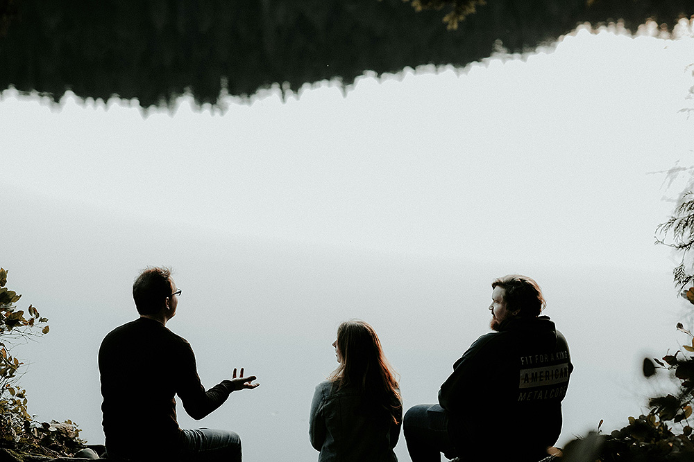 Silhouettes of three people in conversation (Unsplash/Priscilla du Preez)