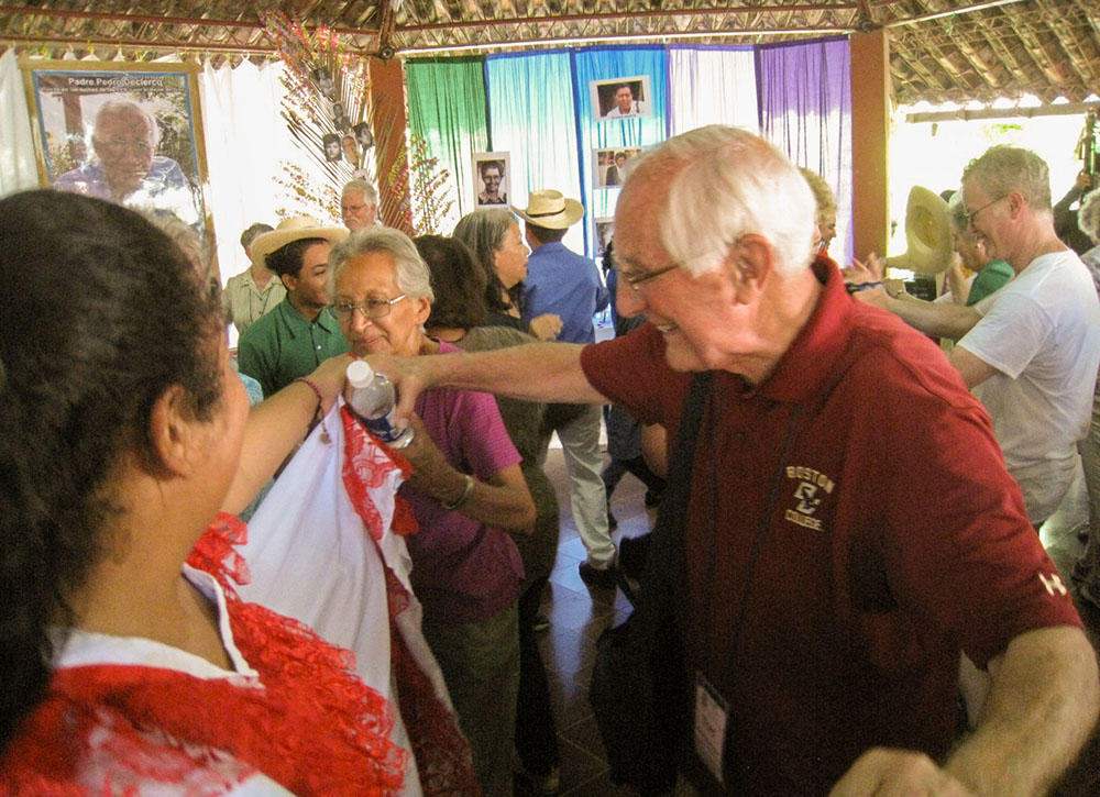 Detroit Auxiliary Bishop Tom Gumbleton is seen with St. Joseph Sr. Elena Jaramillo and folkloric dancers at La Pequeña Comunidad in Nueva Esperanza, El Salvador, in 2015. (Courtesy of SHARE El Salvador)