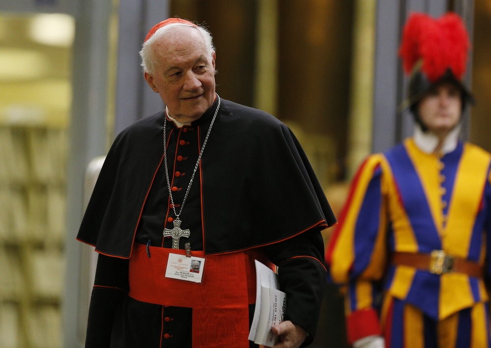 Cardinal pictures walking, with Swiss Guard in background. 