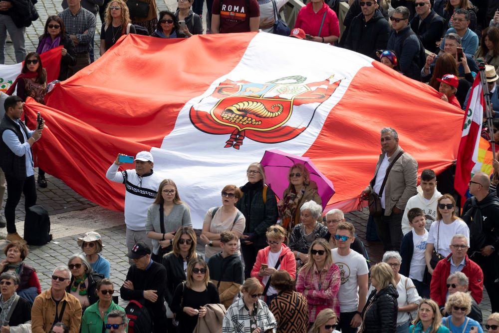 Visitors hold up a flag from Peru in St. Peter's Square at the Vatican March 26, 2023. According to Vatican police, some 35,000 people gathered in the square to join Pope Francis in praying the Angelus. (CNS photo/Vatican Media)