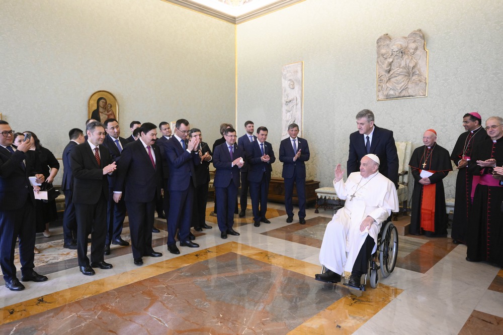 Pope Francis at guests from wheelchair
