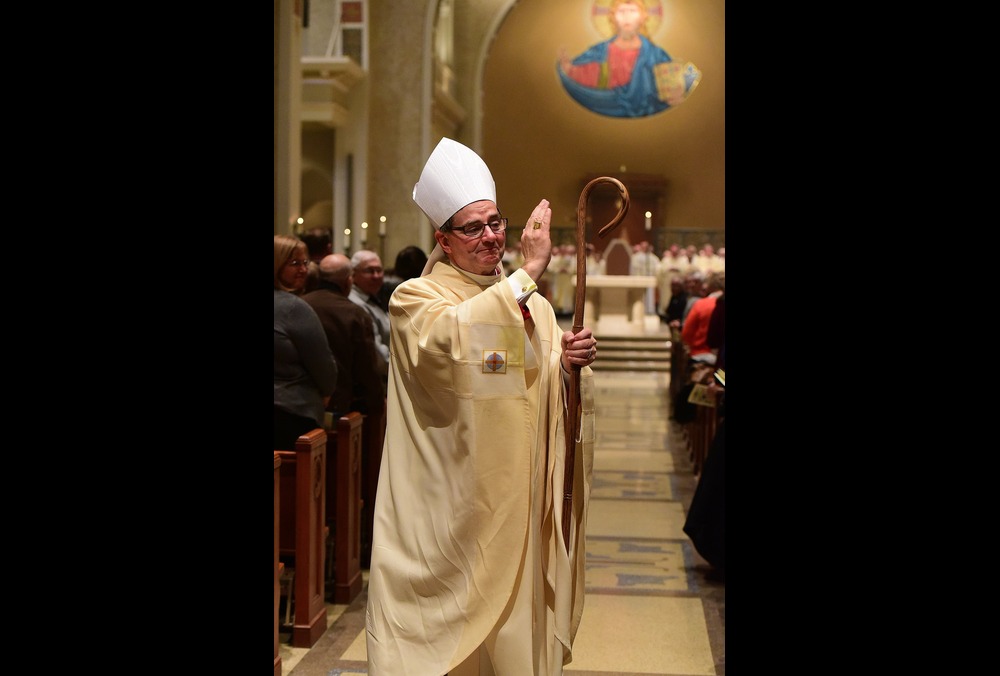 Bishop Power, vested with crozier, blesses assembly. 