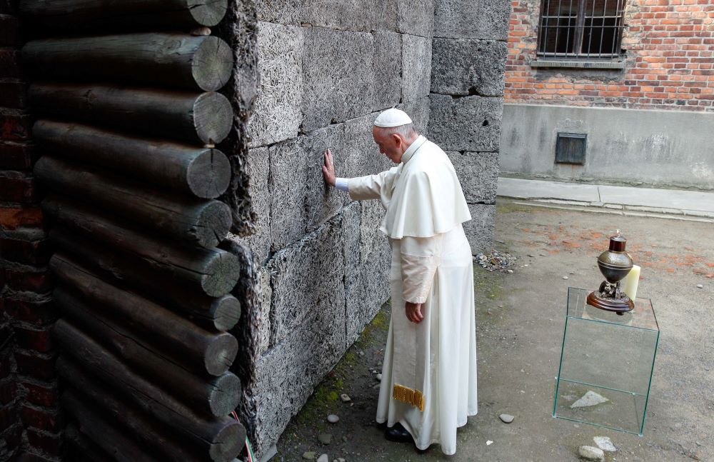 Pope Francis touches the death wall at the Auschwitz Nazi death camp in Oswiecim, Poland, in this July 29, 2016, file photo.
