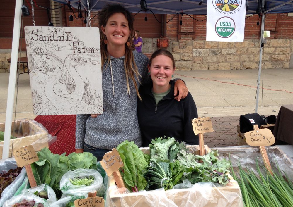 Ashley Neises, left, and Andie Donnan sell some of the produce they raise on Sandhill Farm.