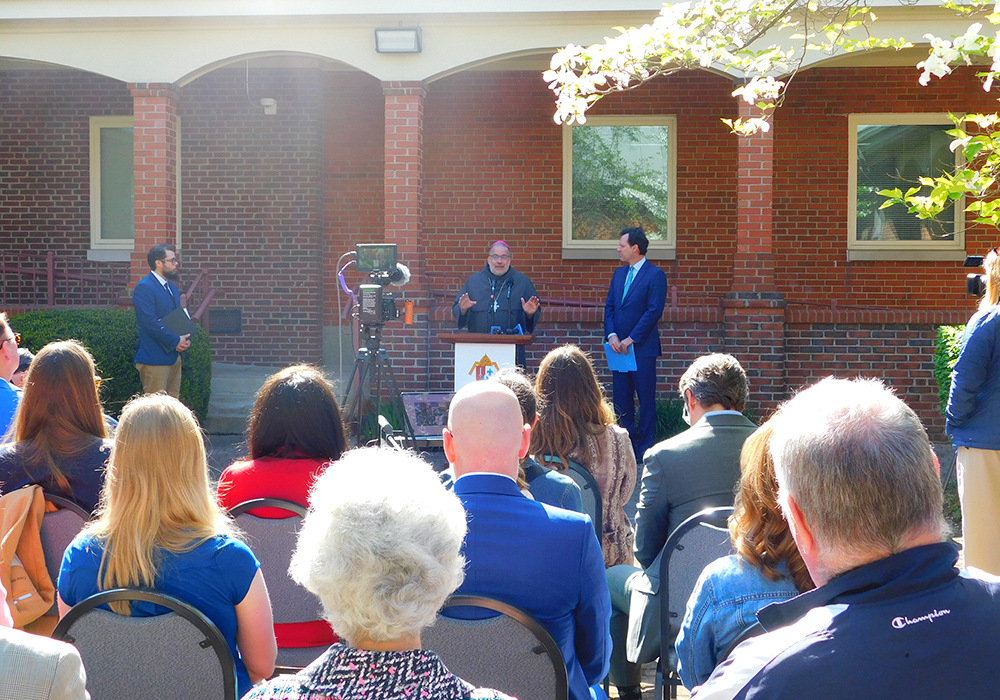 Bishop John Stowe of the Diocese of Lexington, Kentucky, at a press conference April 23 announces a net-zero initiative to make the diocese one of the first in the U.S. to adopt such a commitment. At right is Adam Edelen, founder and CEO of Edelen Renewables. At left is Joshua van Cleef, director of the diocese's peace and justice office. (Courtesy of Diocese of Lexington)