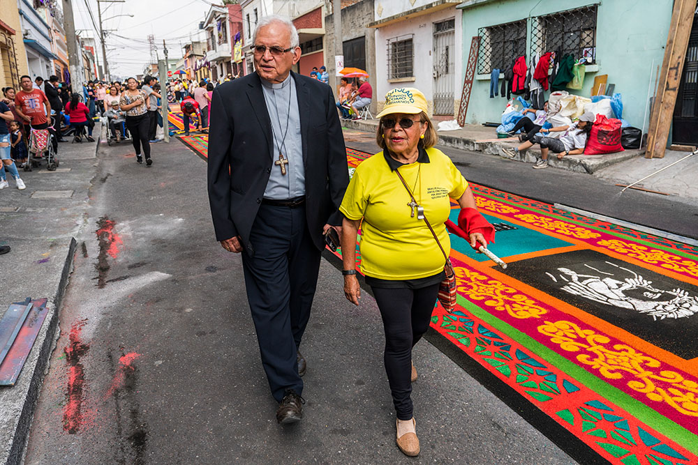 Cardinal Álvaro Ramazzini and a Catholic volunteer walk past a sawdust carpet in Guatemala City March 23. (AP Photo/Moises Castillo)