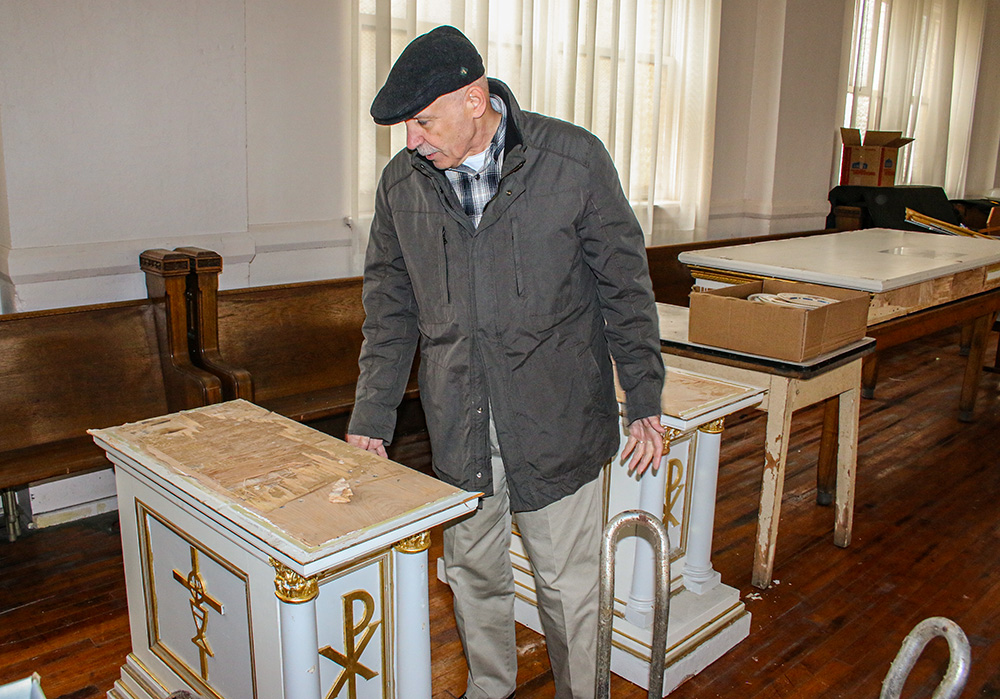 Parishioner Bob Purgert looks at one of the damaged pedestals of the dismantled altar at St. Elizabeth of Hungary Church in Cleveland. (Dennis Sadowski)