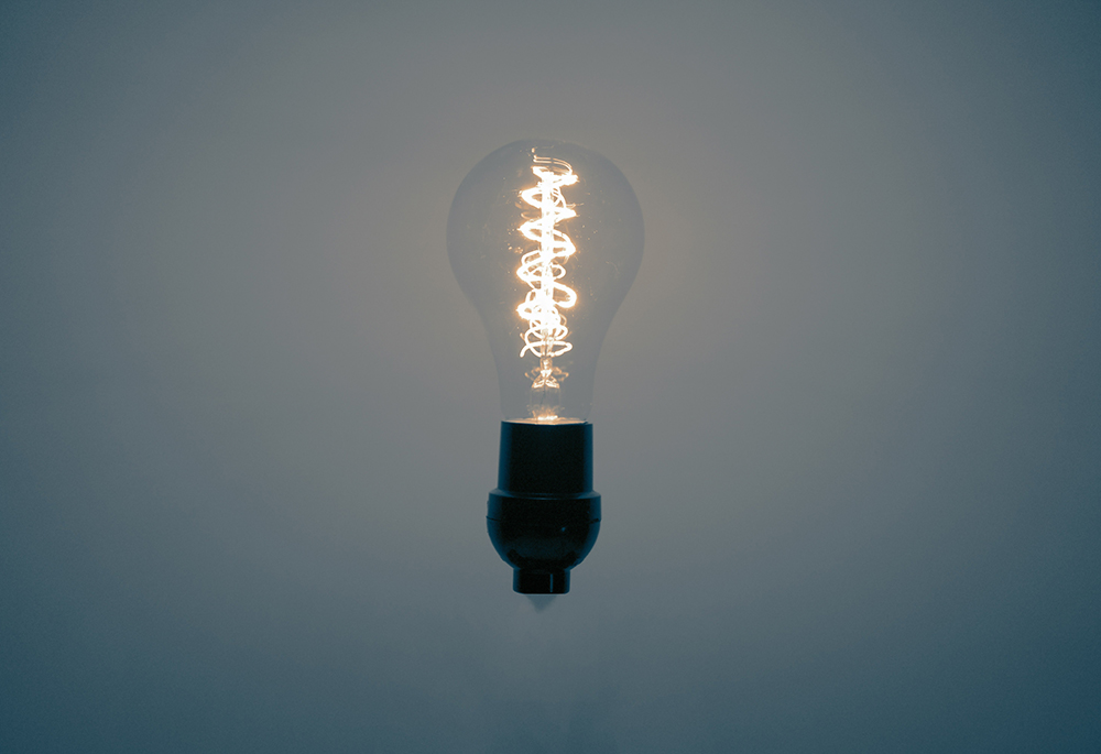 A photo illustration shows a lightbulb against a gray-blue background. (Unsplash/Jack Carter)