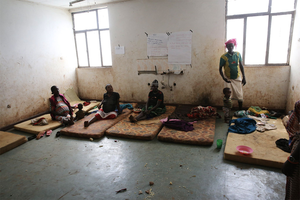 How clean water and faith go hand in hand Women sit on dingy mattresses in squalid room