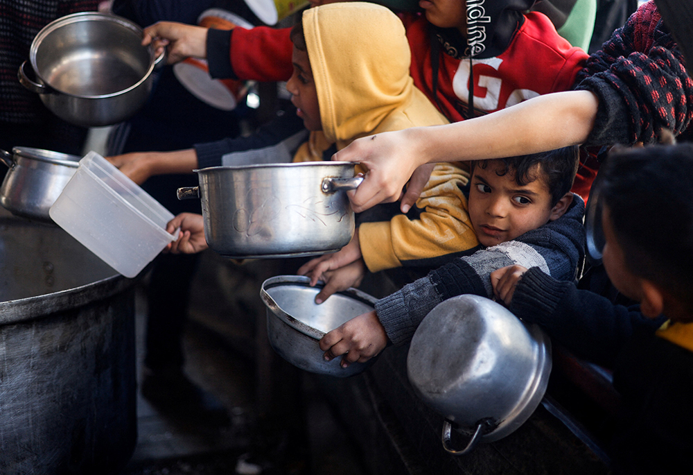 Displaced Palestinian children wait to receive food March 5 in Rafah, in the southern Gaza Strip, that was cooked by a charity kitchen amid shortages of food supplies as the ongoing conflict between Israel and the Palestinian Islamist group Hamas continues. (OSV News/Reuters/Mohammed Salem)