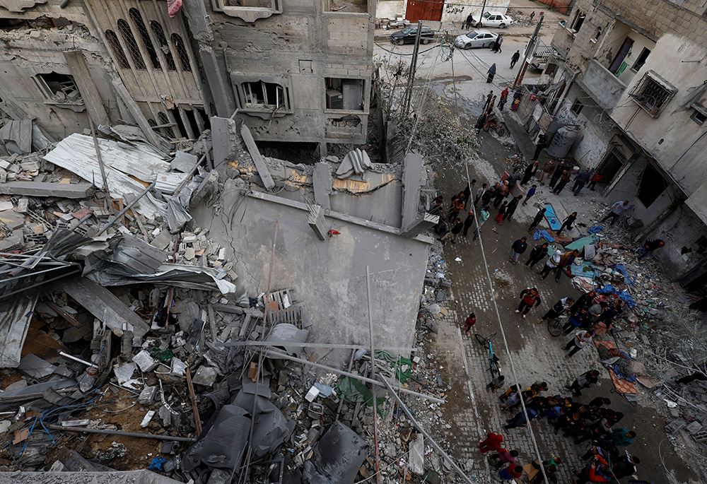 Palestinians inspect the site of an Israeli airstrike on a house, amid the ongoing conflict between Israel and the Palestinian Islamist group Hamas, March 24 in Rafah, in the southern Gaza Strip. (OSV News/Reuters/Mohammed Salem)