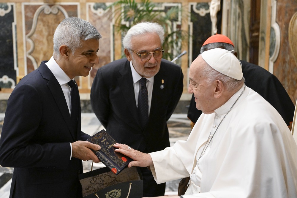 Pope Francis, mayors and governors, Climate Resiliency Conference. Pope, seated, smiles amid discussion with standing mayor.