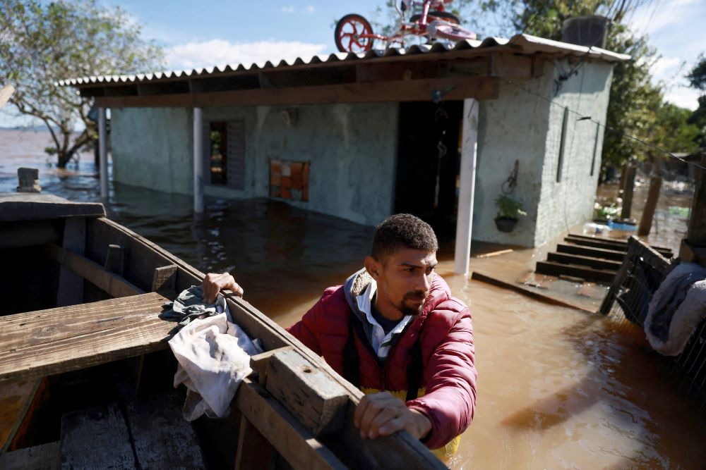 Valderci Trindade, 24, who lost his house, tries to save useful items May 14, 2024, in an area flooded by heavy rains in the Serraria neighborhood of Porto Alegr in Brazil's Rio Grande do Sul state. (OSV News photo/Diego Vara, Reuters)