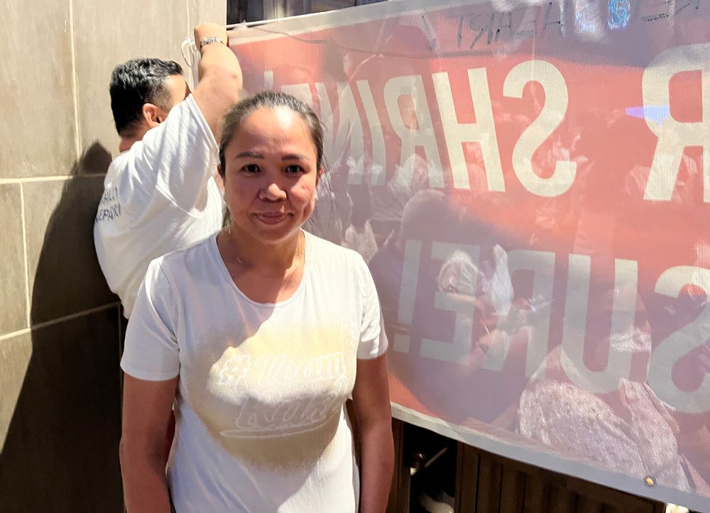 Debra Tagle was one of several members of the Filipino community who attended the forum with banners to advocate against the closure of additional facilities.