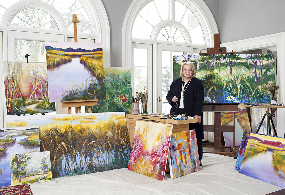Janet Hennessey Dilenschneider poses with some of her paintings. The artist currently has an exhibit at the gallery of the Sheen Center for Thought and Culture in Manhattan, entitled "Come to the Light." (Courtesy of Sheen Center for Thought and Culture)