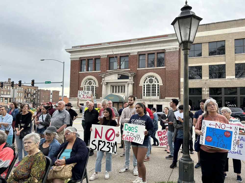 Iowa immigration law People stand on street holding signs in opposition to bill