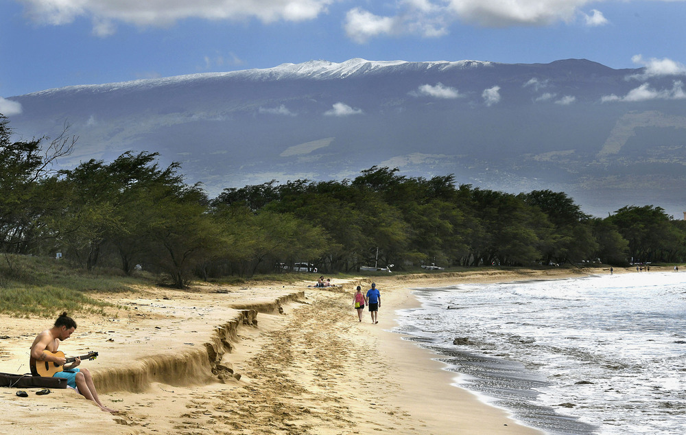 In Hawaii, Maui council opposes US Space Force plan to build new telescopes on Haleakala volcano Longview of people walking down beach with mountain in background