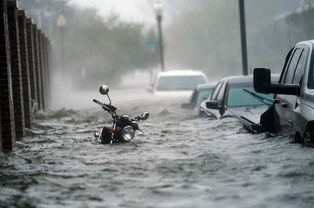 Sea levels, temperatures, and coastal economies Flood waters rush through nearly submerged vehicles in street