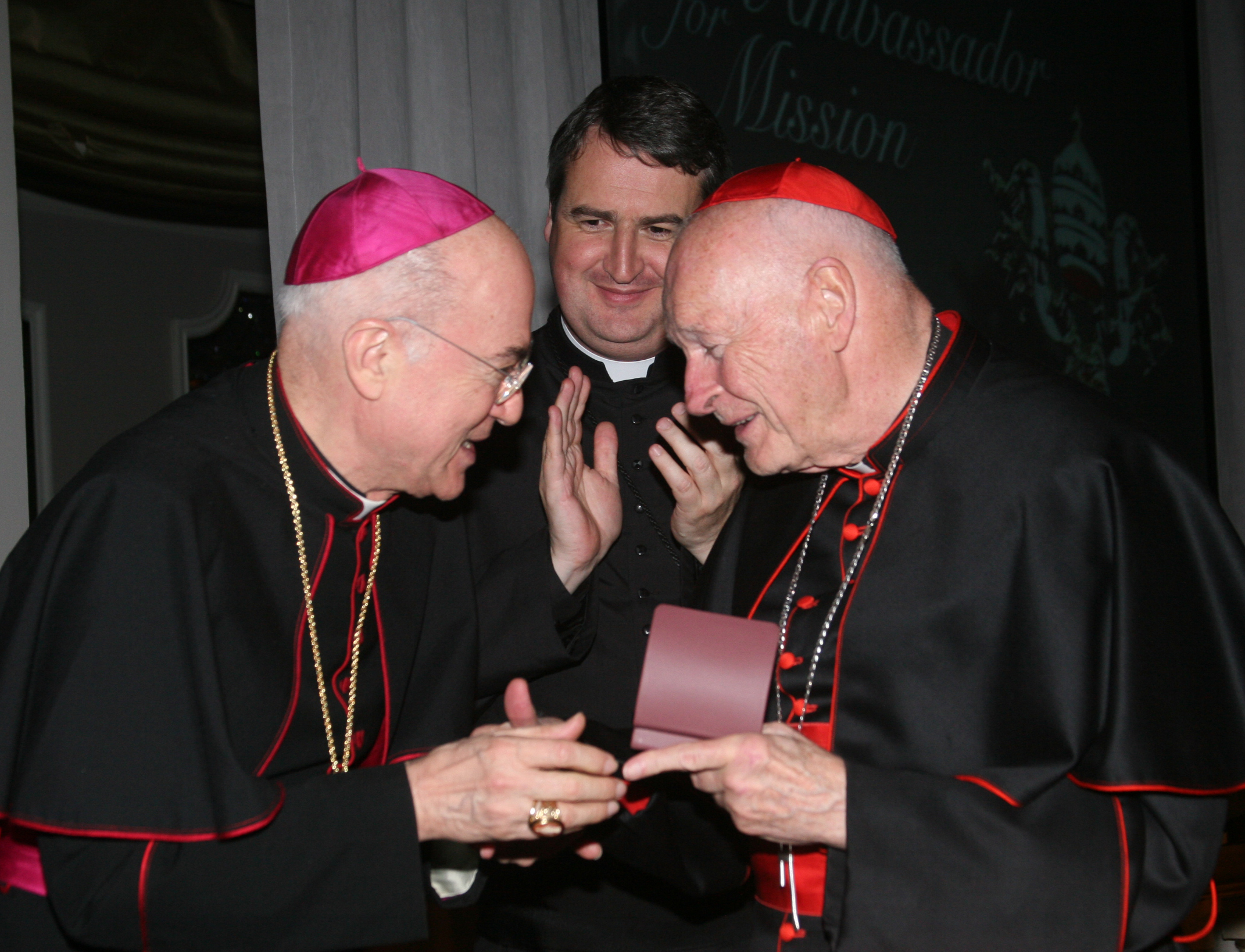 Archbishop Carlo Maria Vigano, then nuncio to the United States, congratulates then-Cardinal Theodore McCarrick of Washington at a gala dinner sponsored by the Pontifical Missions Societies in New York in May 2012. The archbishop has since said Cardinal McCarrick already was under sanctions at that time, including being banned from traveling and giving lectures. Oblate Fr. Andrew Small, center, director of the societies, said Vigano never tried to dissuade him from honoring the cardinal at the gala. (CNS/PMS/Michael Rogel) Archbishop Carlo Maria Vigano, then nuncio to the United States, congratulates then-Cardinal Theodore McCarrick of Washington at a gala dinner sponsored by the Pontifical Missions Societies in New York in May 2012. The archbishop has since said Cardinal McCarrick already was under sanctions at that time, including being banned from traveling and giving lectures. Oblate Fr. Andrew Small, center, director of the societies, said Vigano never tried to dissuade him from honoring the cardinal at the gala. (CNS/PM