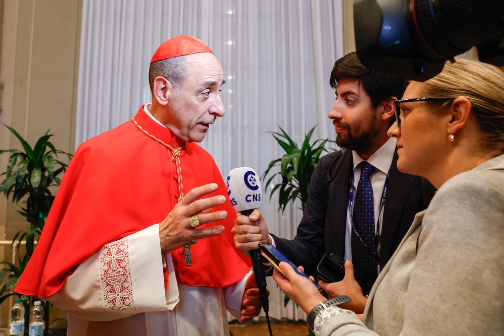Cardinal Victor Manuel Fernandez, 2023. Fernandez wears red Cardinal's clerics and speaks to reporters.