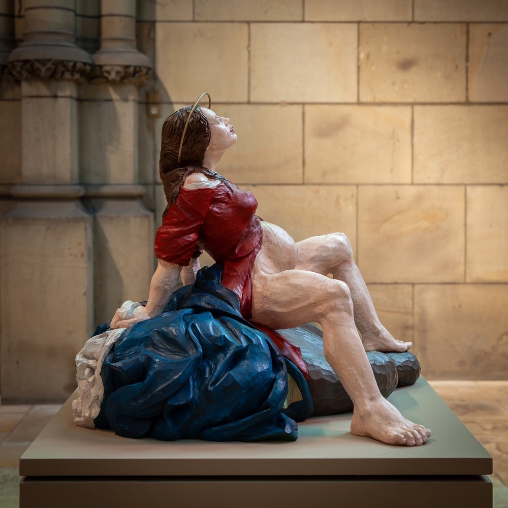 Esther Strauss Virgin Mary in labor sculpture, Cathedral of Linz, Austria Visceral, painted sculpture, installed on pillar, pictured in profile.