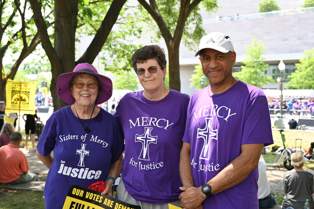Poor People's Campaign rally June 29 Three people in a row, wearing purple Sisters of Mercy of shirts