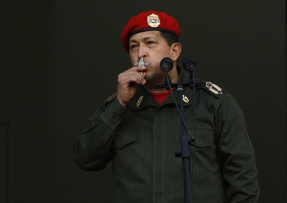 Hugo Chavez, crucifix, 2011. Chavez, in military regalia, kisses crucifix.