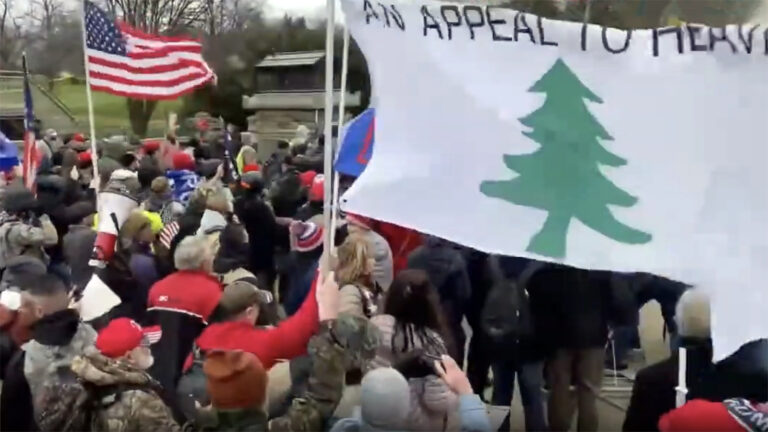 Jan. 6, 2021 insurrection. Swarming group holds various flags including "An Appeal to Heaven."