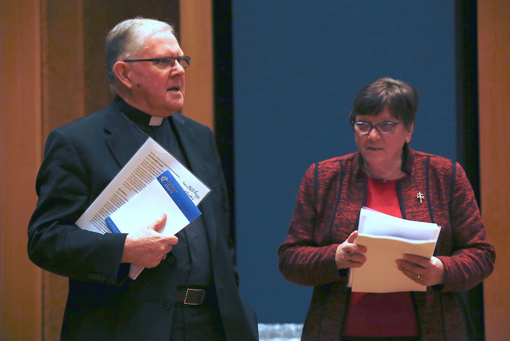 Archbishop of Brisbane and president of the Australian bishops' conference, Mark Coleridge, and Josephite sister and president of Catholic Religious Australia, Monica Cavanagh, Aug. 31, 2018. Coleridge and Cavanagh both standing, holding presentation materials.
