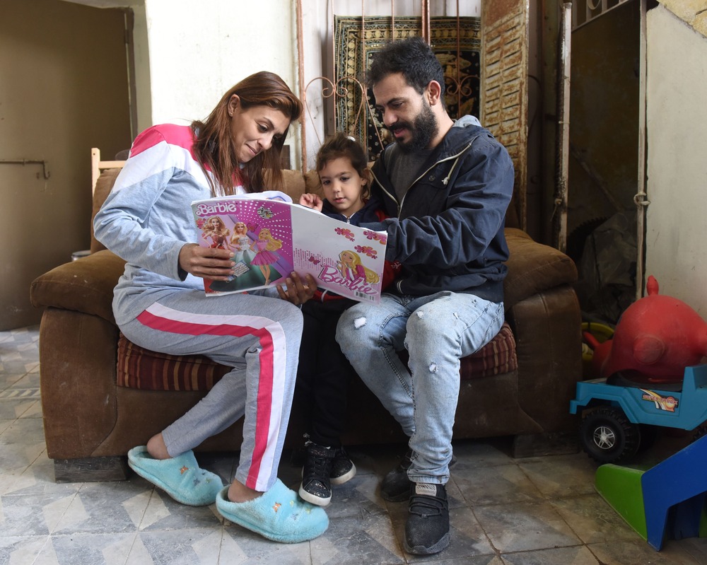 Family reading. Man and woman read with little girl.