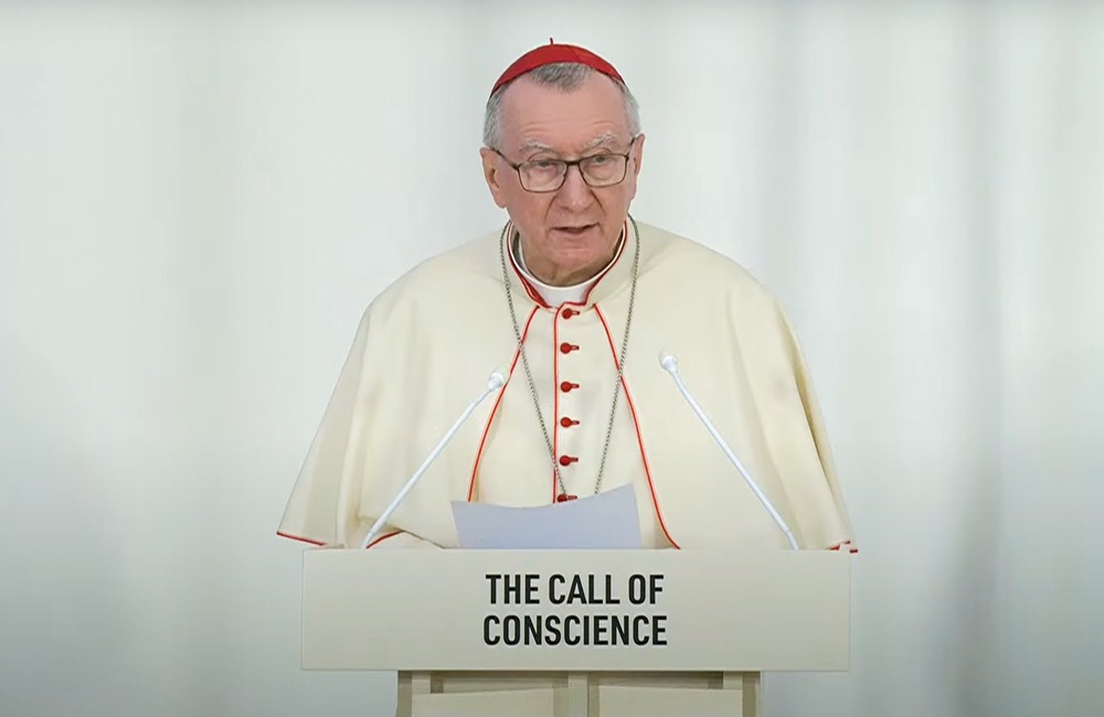 Cardinal Parolin, Vatican Secretary of State, Dubai, 2023. Parolin wearing white cassock piped with Cardinal's red and red zucchetto stands at podium reading remarks.